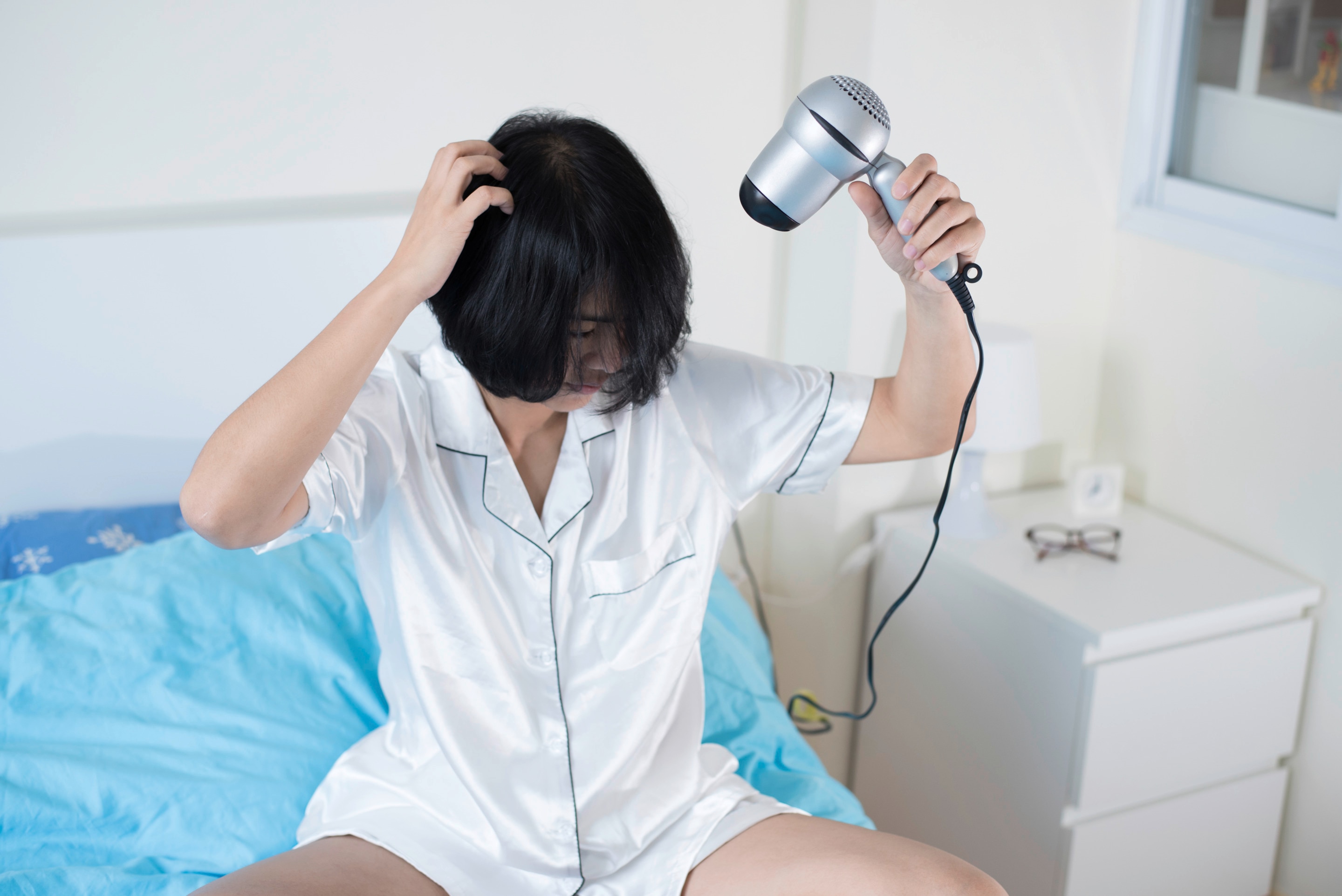 Asian woman using hairdryer