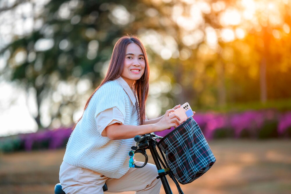 A woman riding a bicycle at an outdoor park.