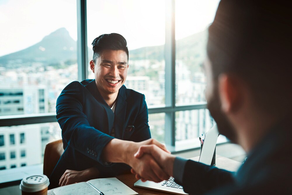 Asian man shaking hands after a job interview.