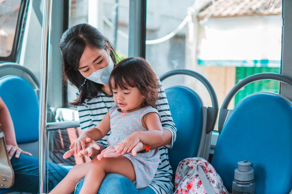 Asian mom and daughter playing on the train.