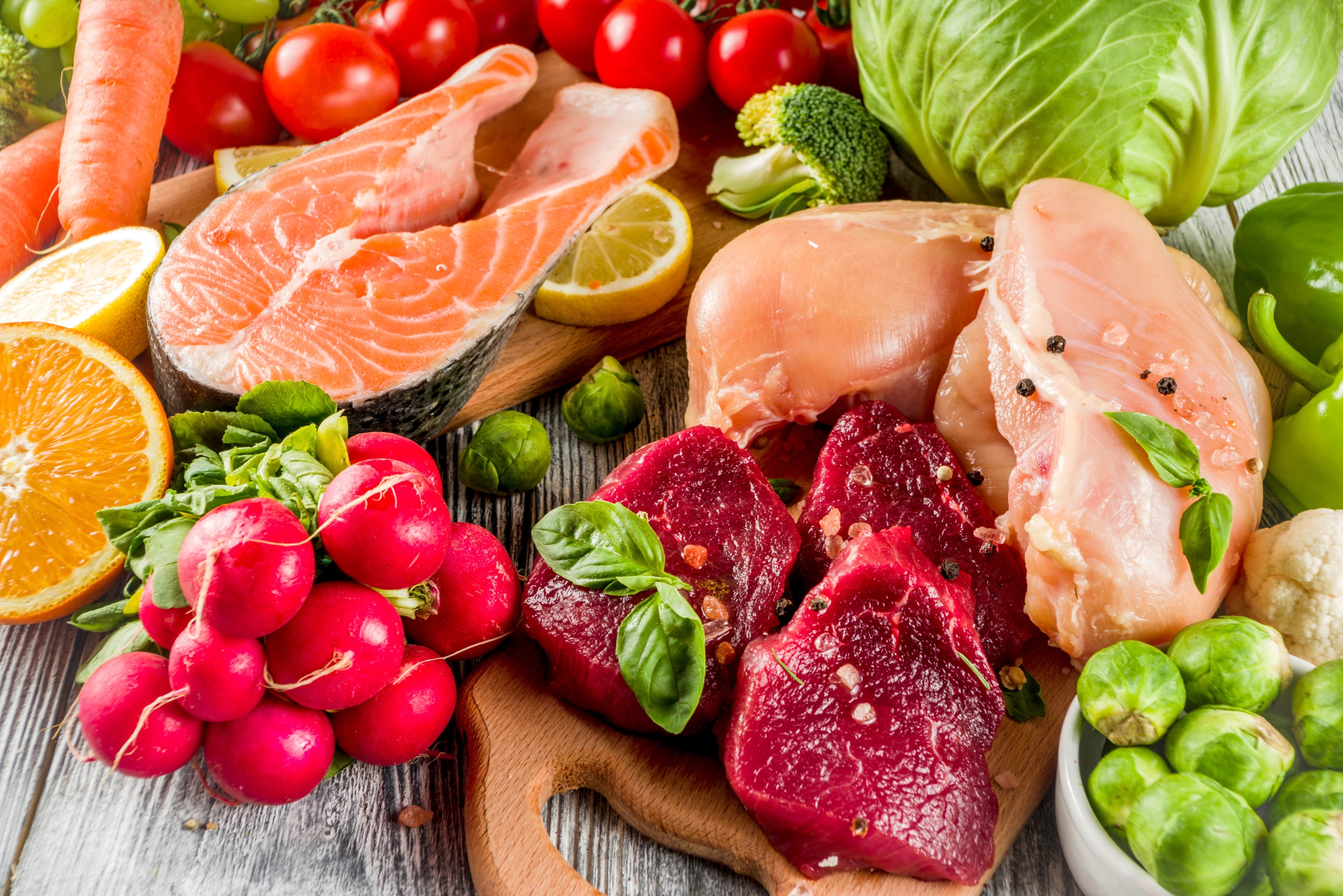 A photo of fresh meats, fruits, and vegetables