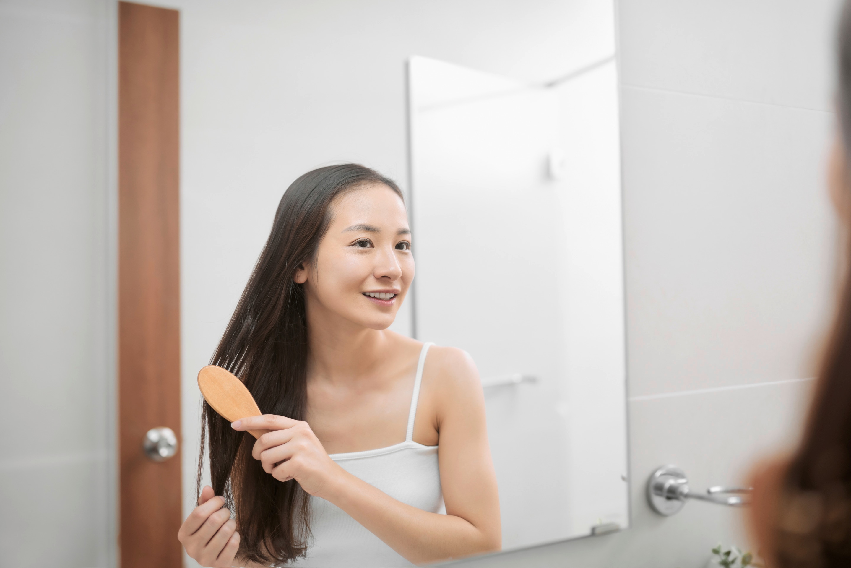 Young Asian woman combing wet hair