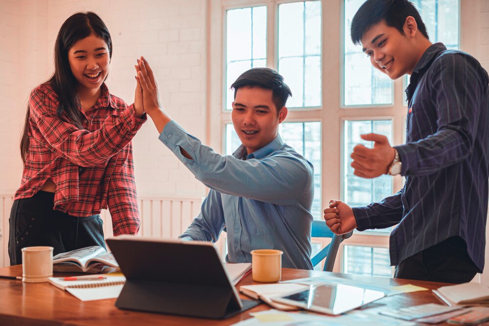 Three colleagues happily celebrating.