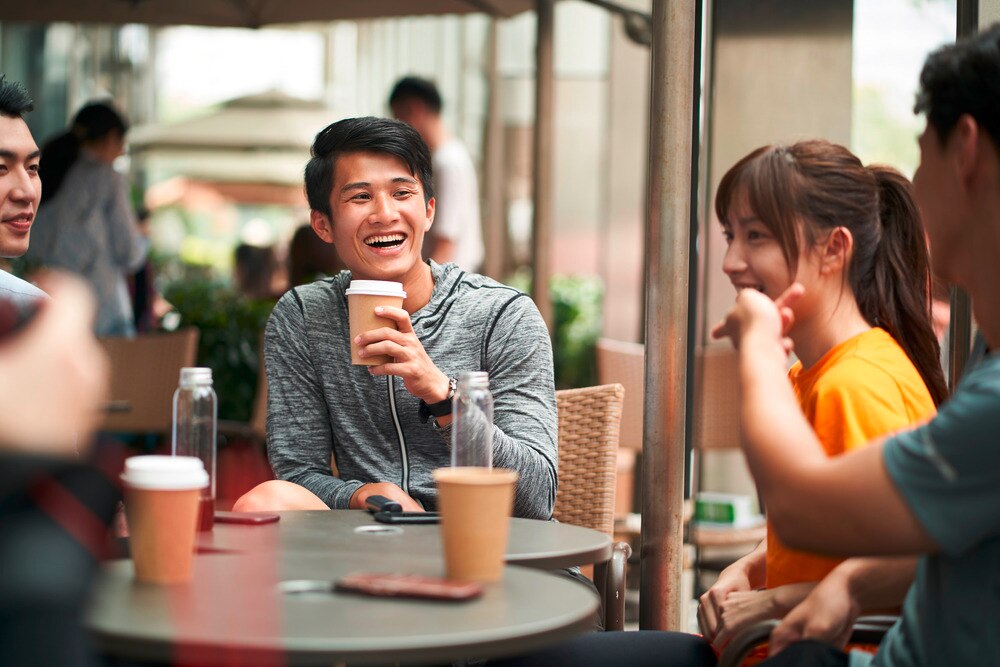 A group of friends chatting and enjoying their coffee al fresco.