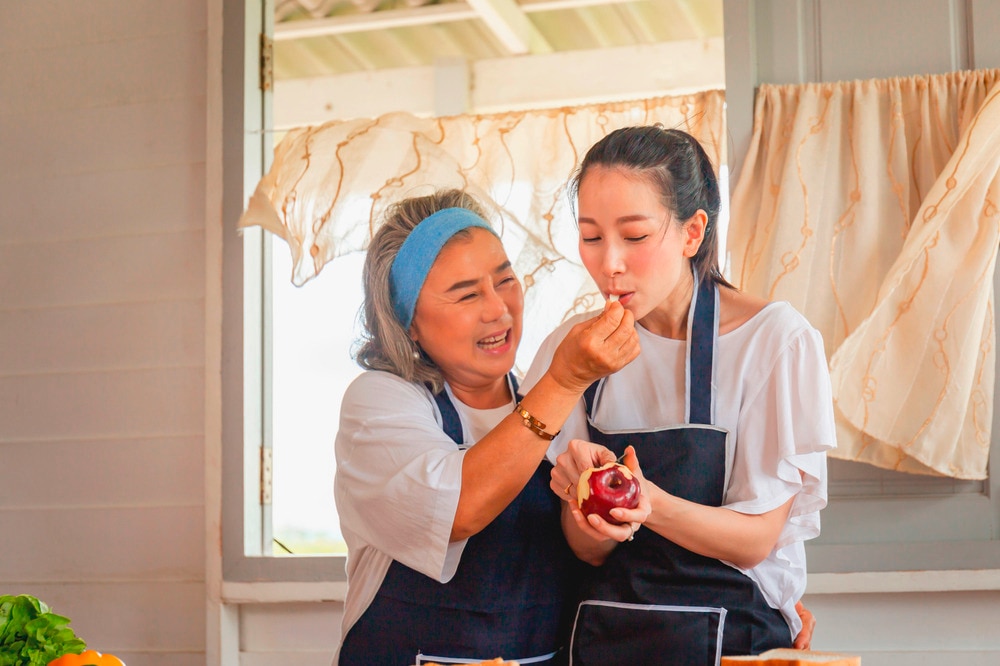 Woman cooking together with her grandmother in the kitchen.