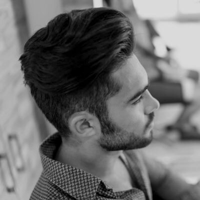 A guy wth freckles, running his hands through his hair.