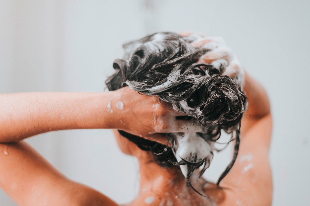 Woman shampooing her hair in the shower.