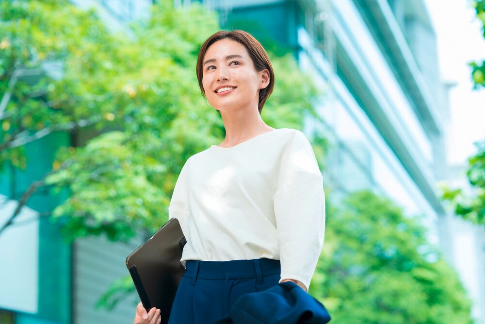 Smiling woman with short bixie hair dressed up in office attire.