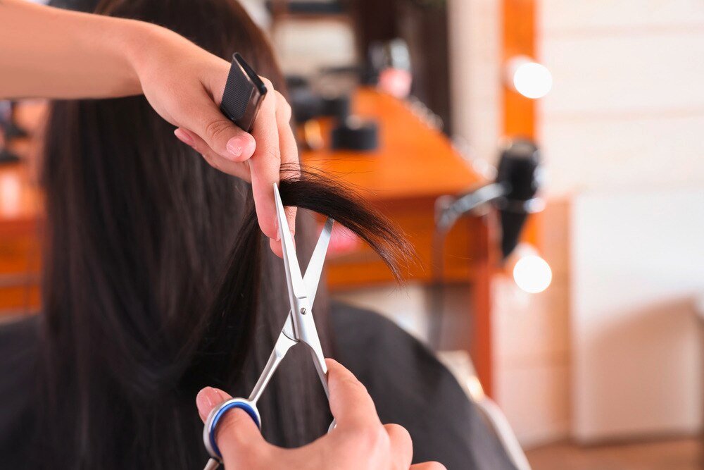 A woman getting her hair trimmed at a salon.
