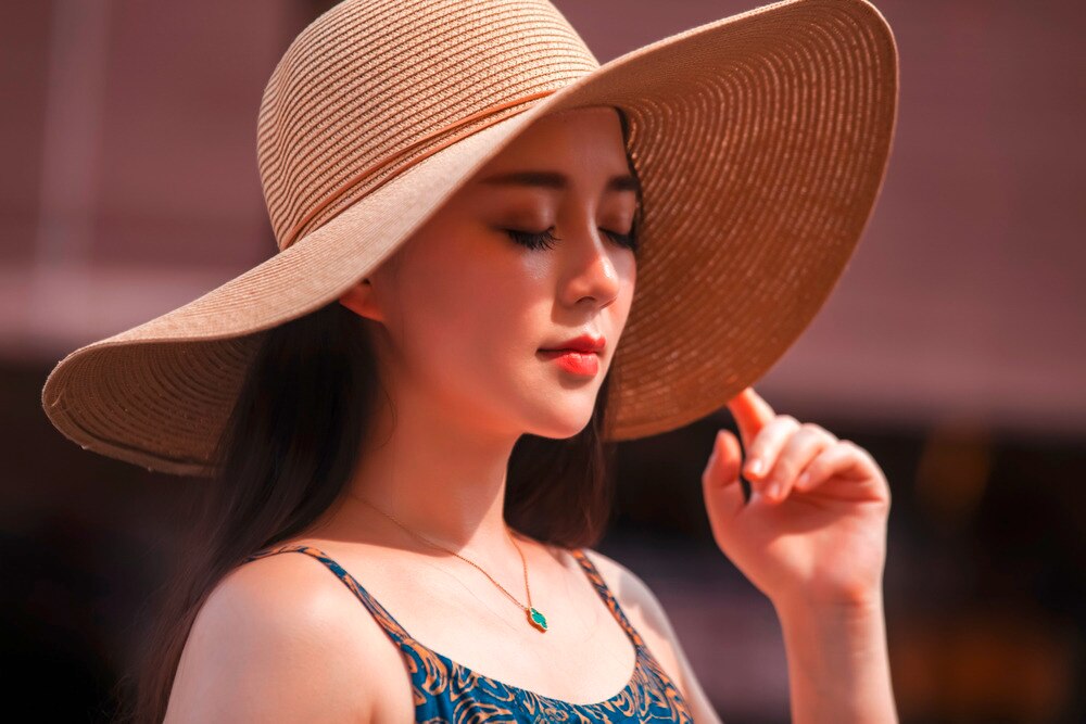 Woman wearing wide-brimmed hat outdoors.