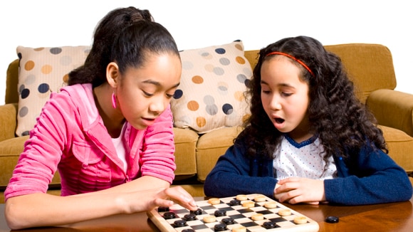 Two young girls playing a board game