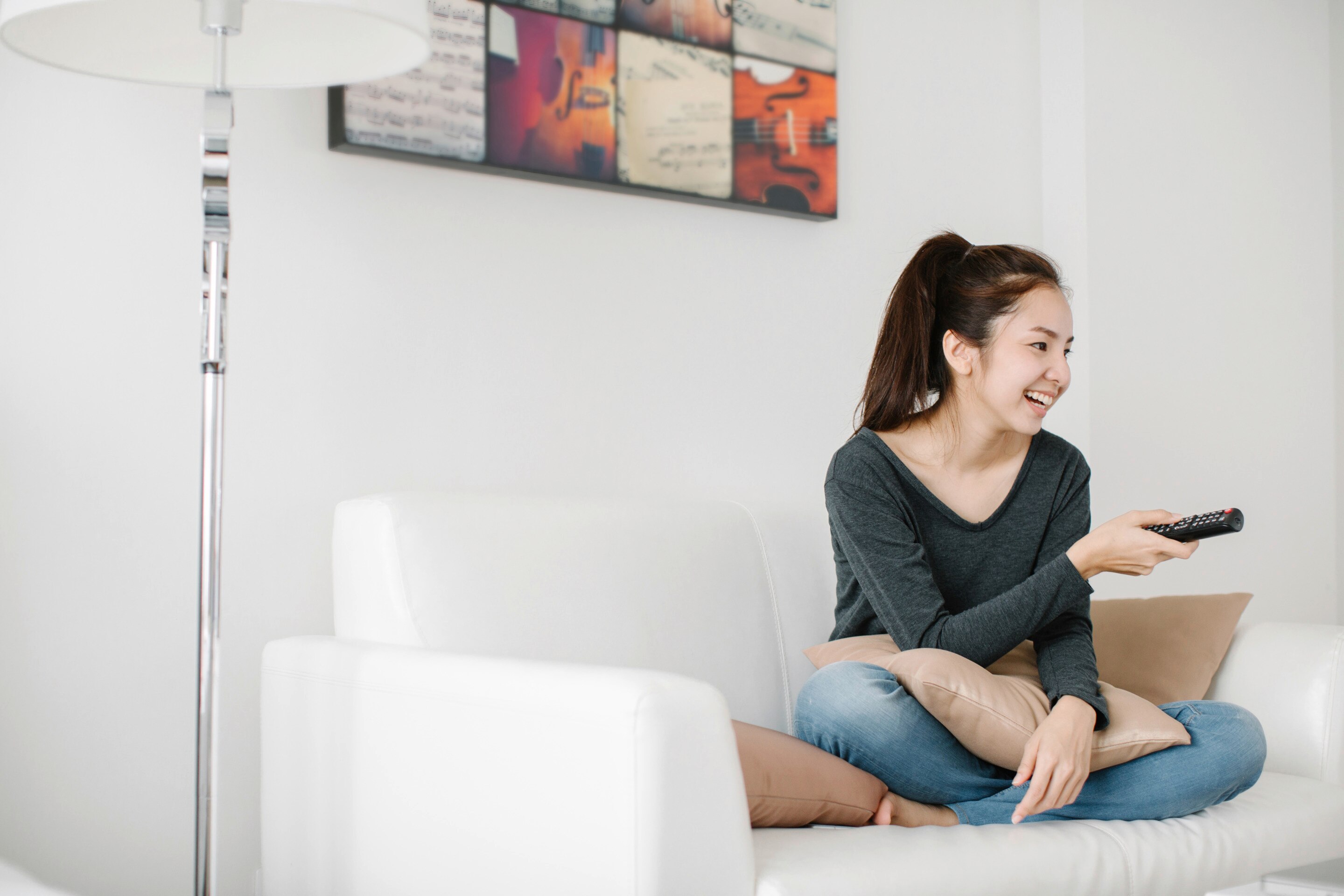 An Asian woman watching tv at home
