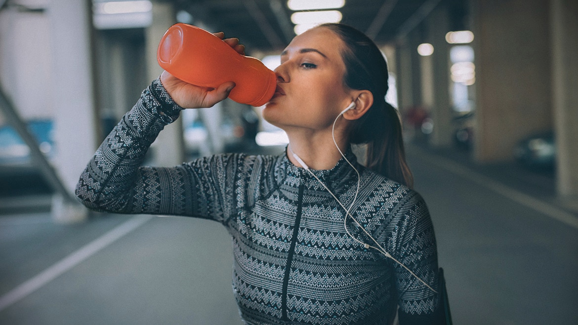 Women at gym drinking water Text