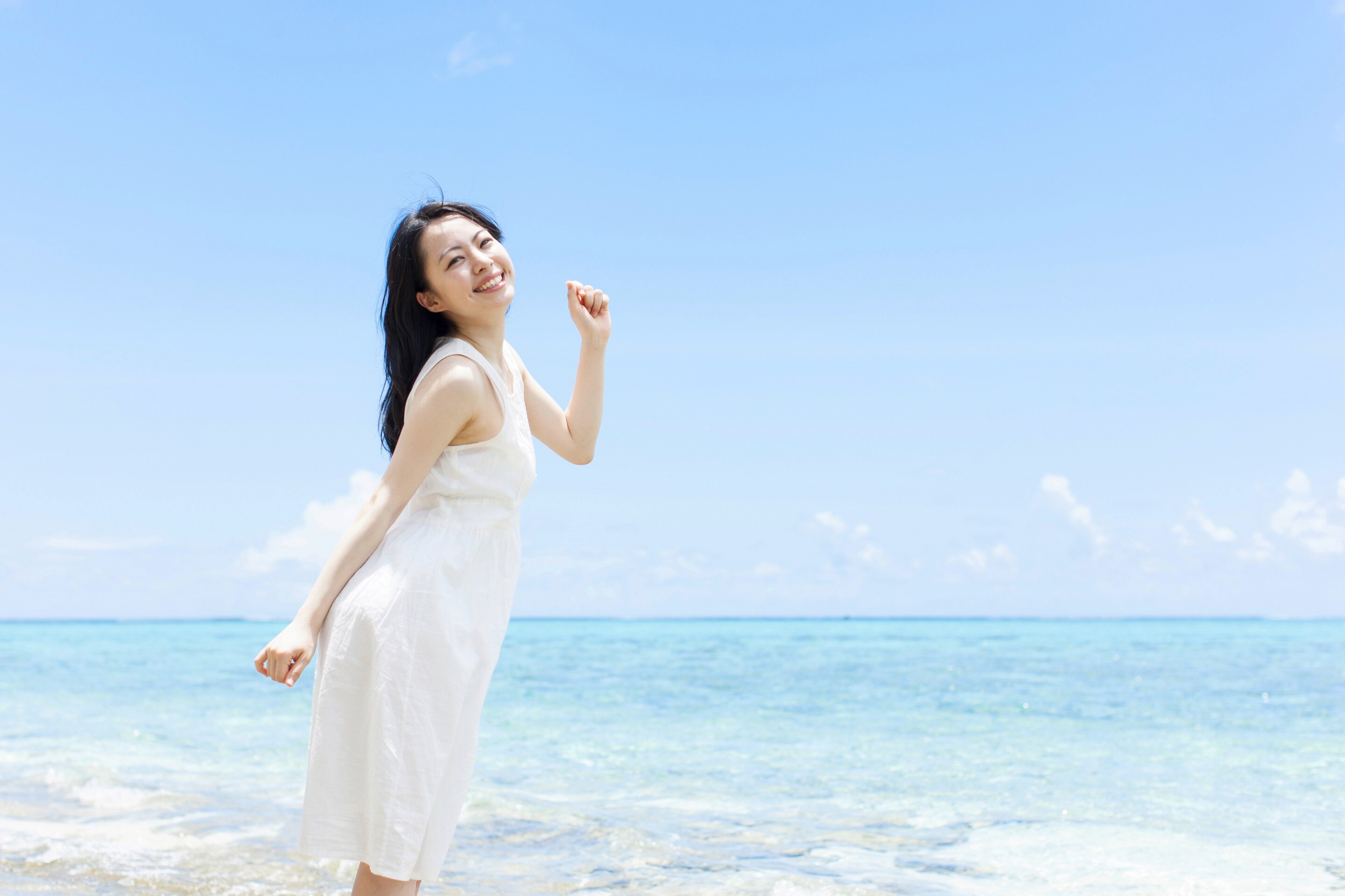 Beautiful Asian girl smiling by the beach
