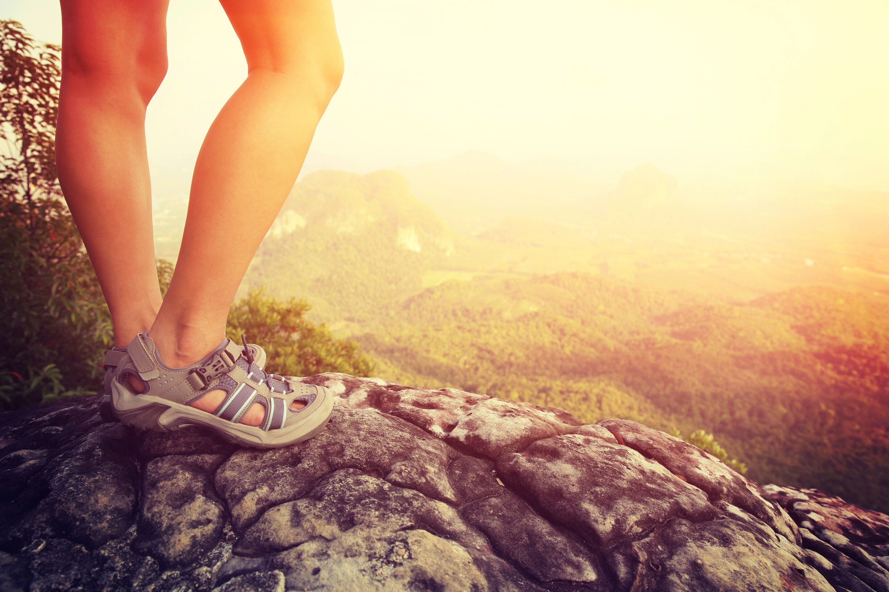 A close-up of hiking sandals on a boulder