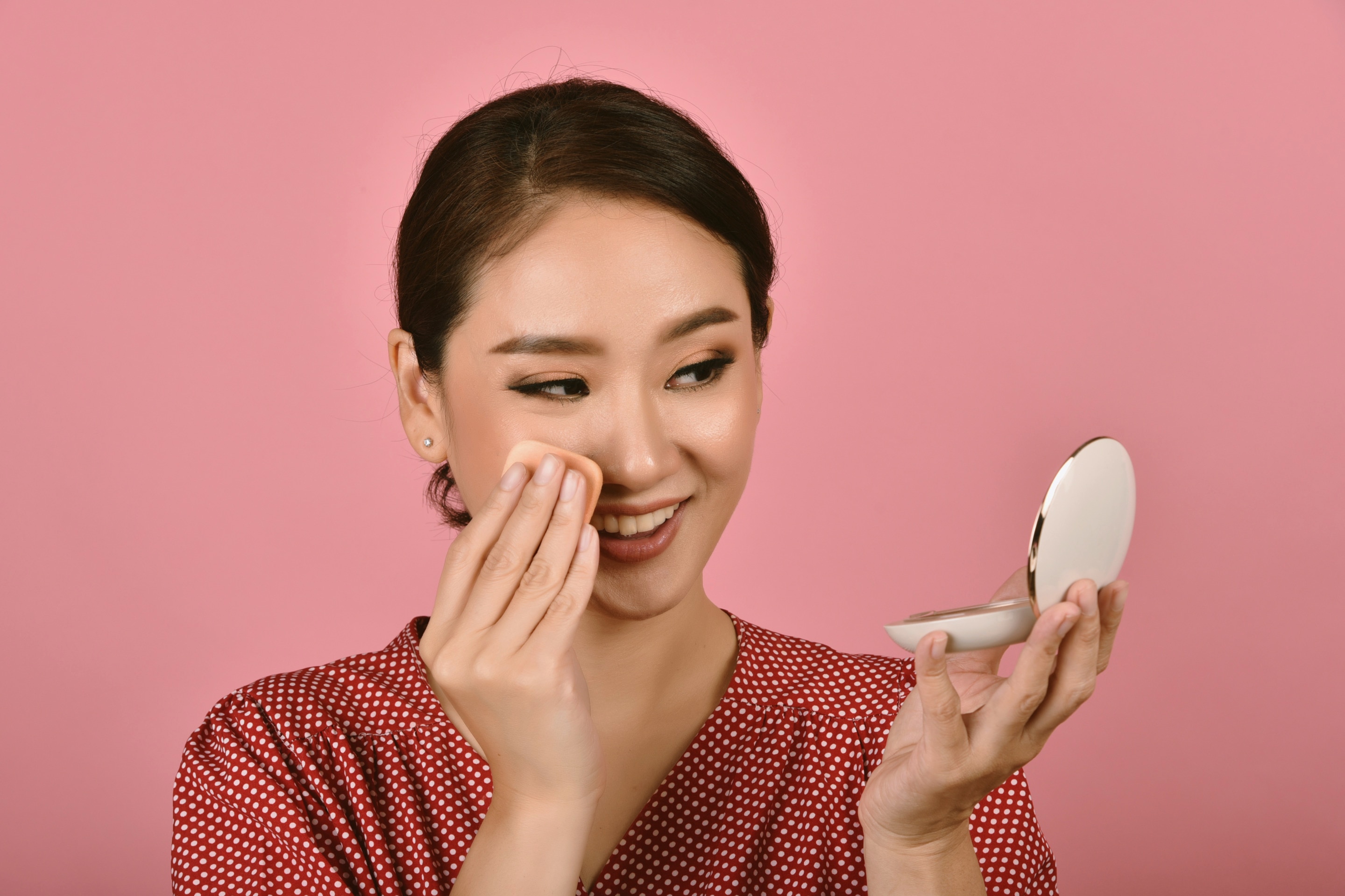 An Asian woman applying powder