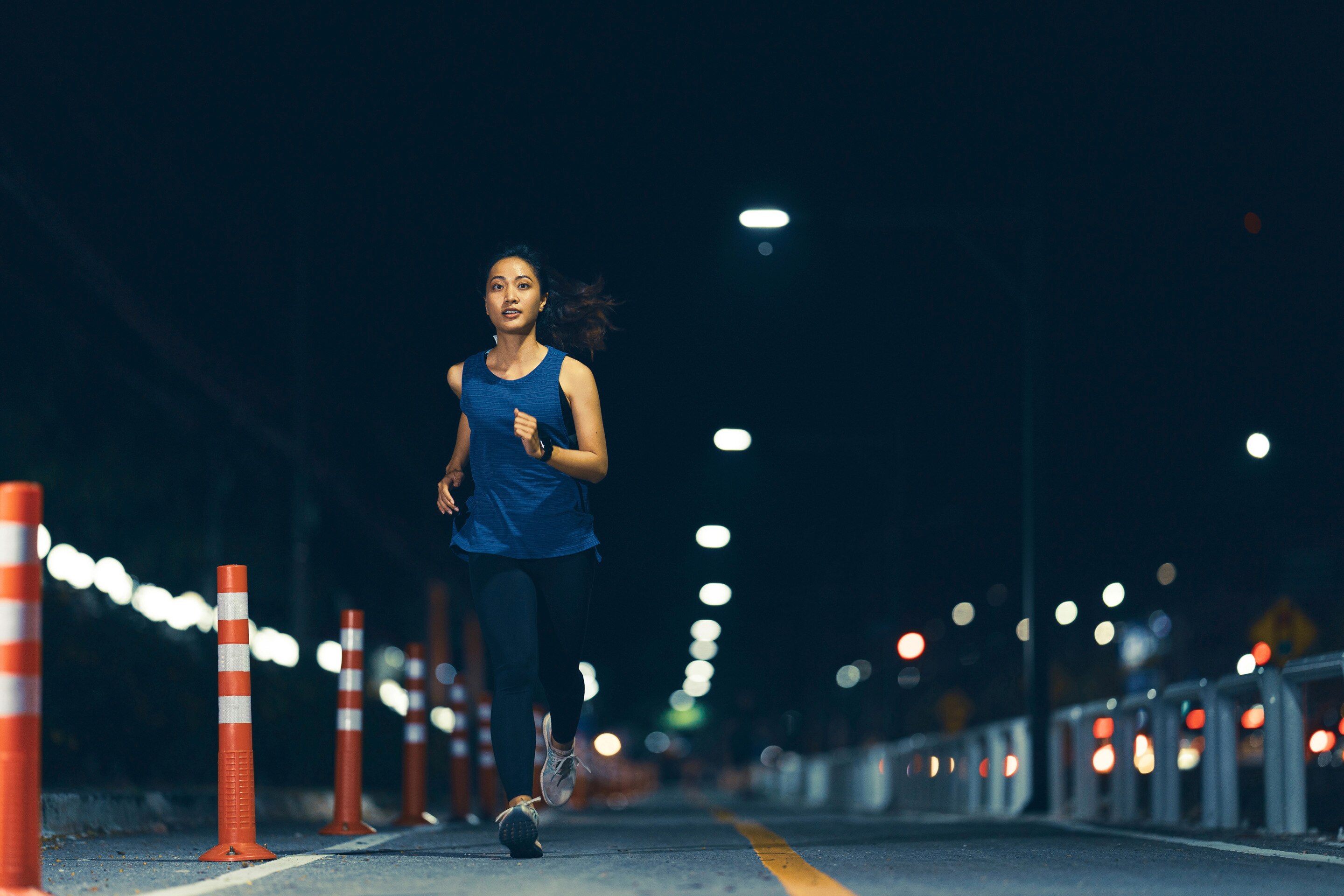 Asian woman running on the street at night 