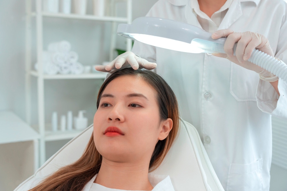 Woman getting her scalp checked by a dermatologist.