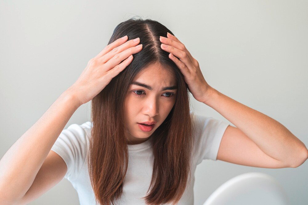 Woman with long hair checking her scalp eczema.