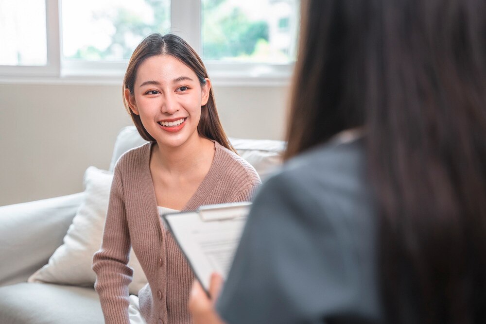 A woman smiling while talking to a therapist.