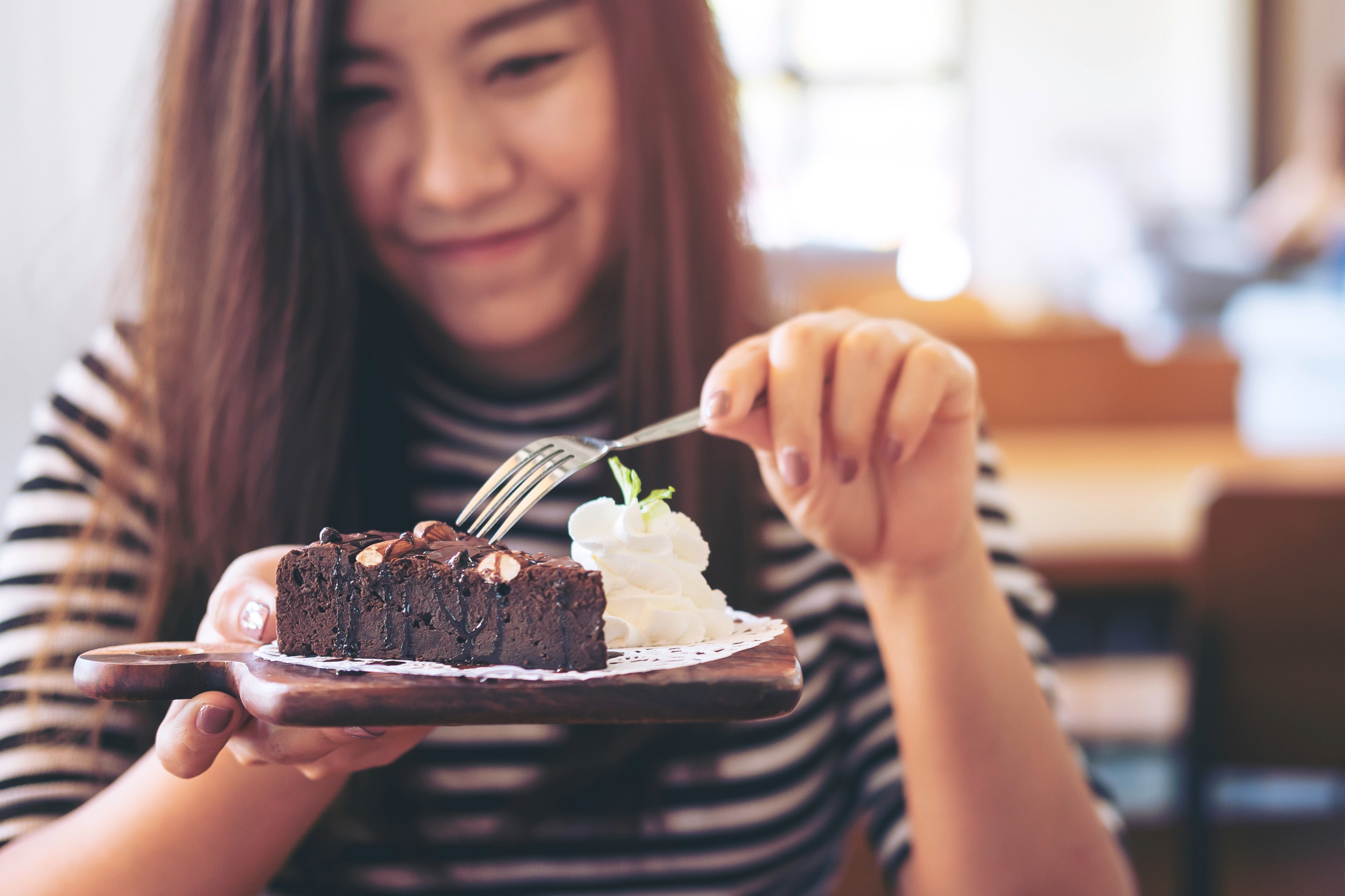 Asian woman eating a brownie