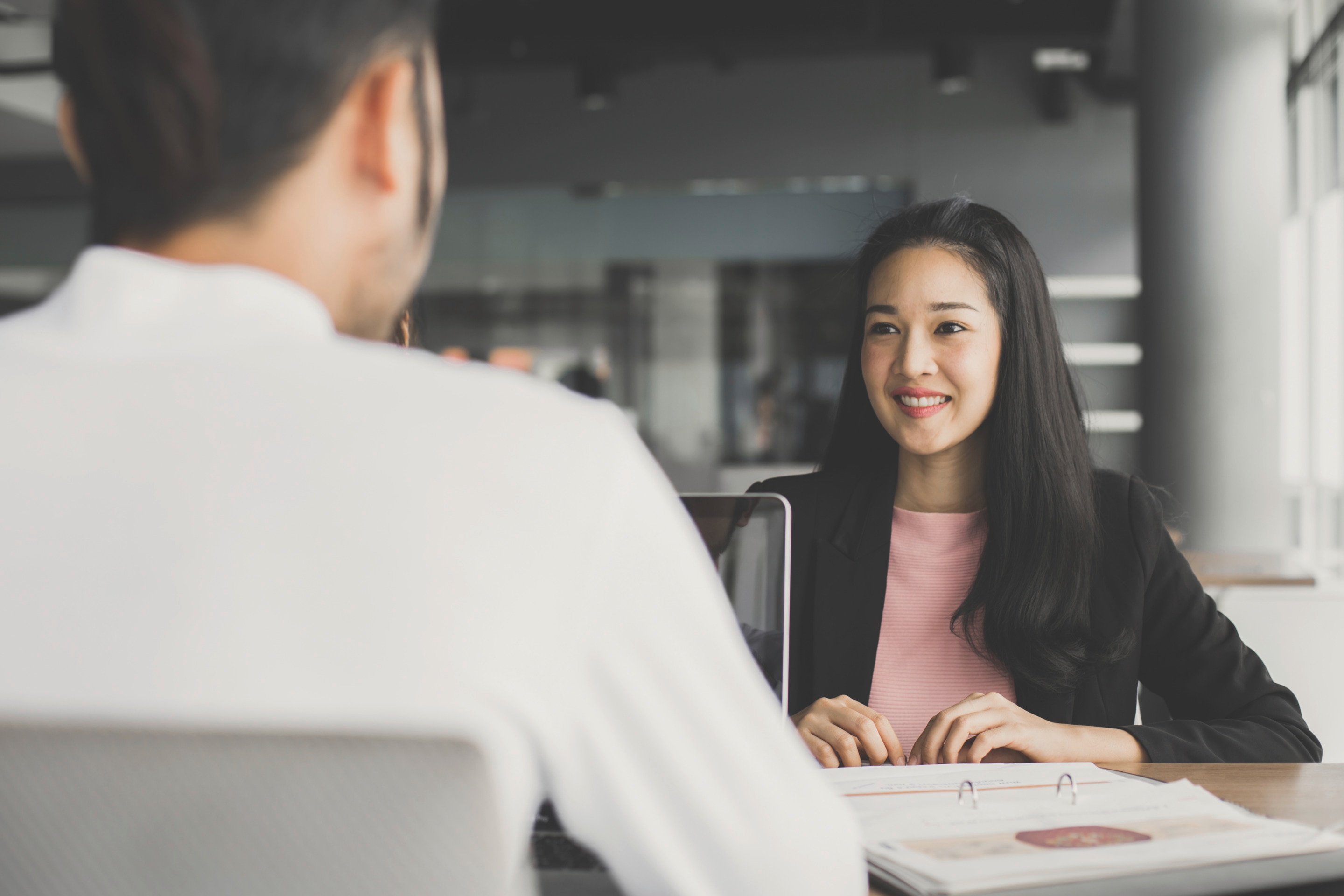 Asian woman talking to a man at the office 