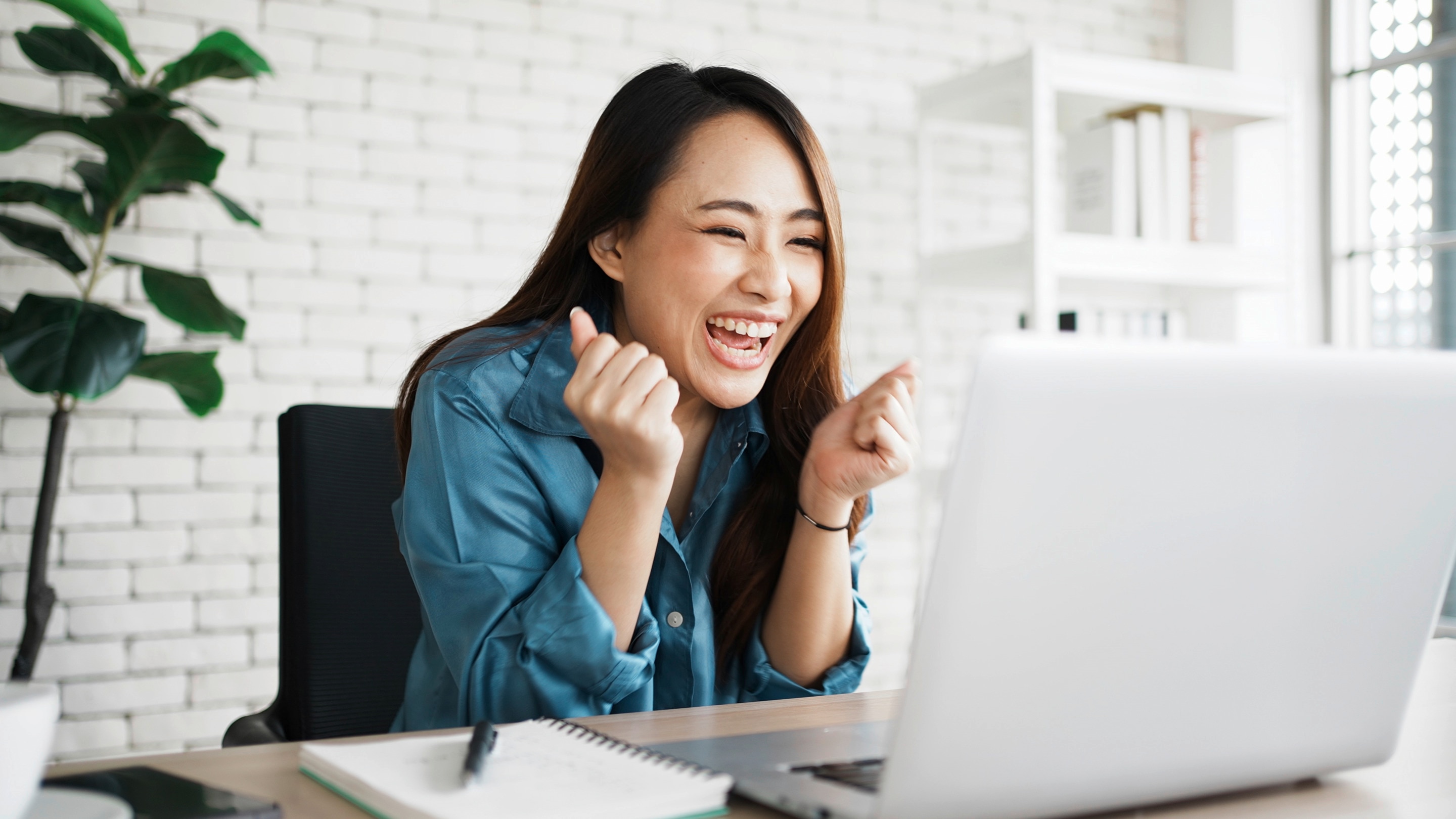 Asian businesswoman smiling before her laptop