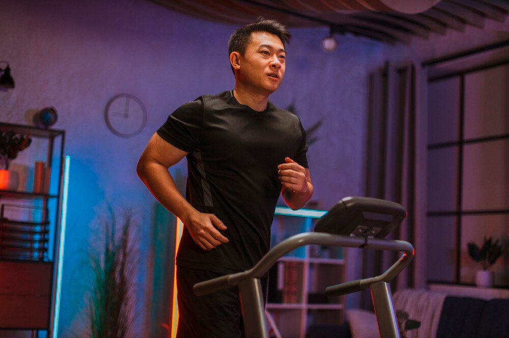 Man running on a treadmill at his home gym.
