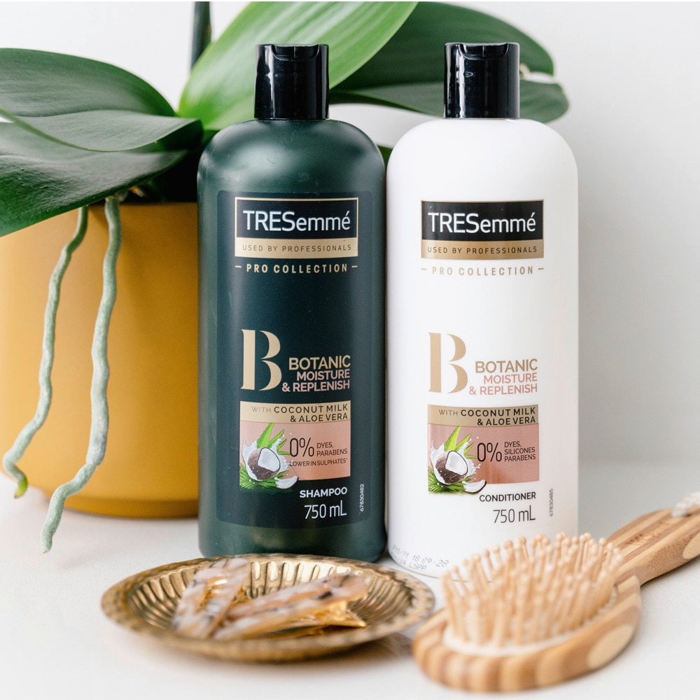 Tresemme botanic shampoo and conditioner in situation with a plant and a hair brush