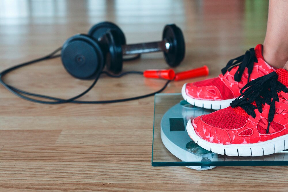 Closeup of a woman’s feet on a weighing scale.
