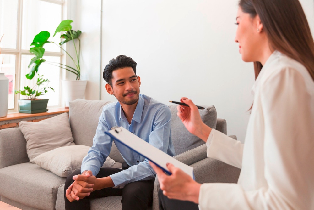 Man in light blue shirt in discussion with a female doctor.