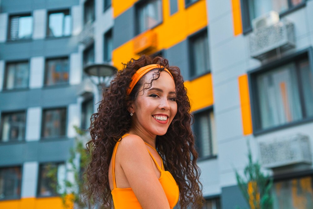 A portrait of smiling woman with long, curly hair.