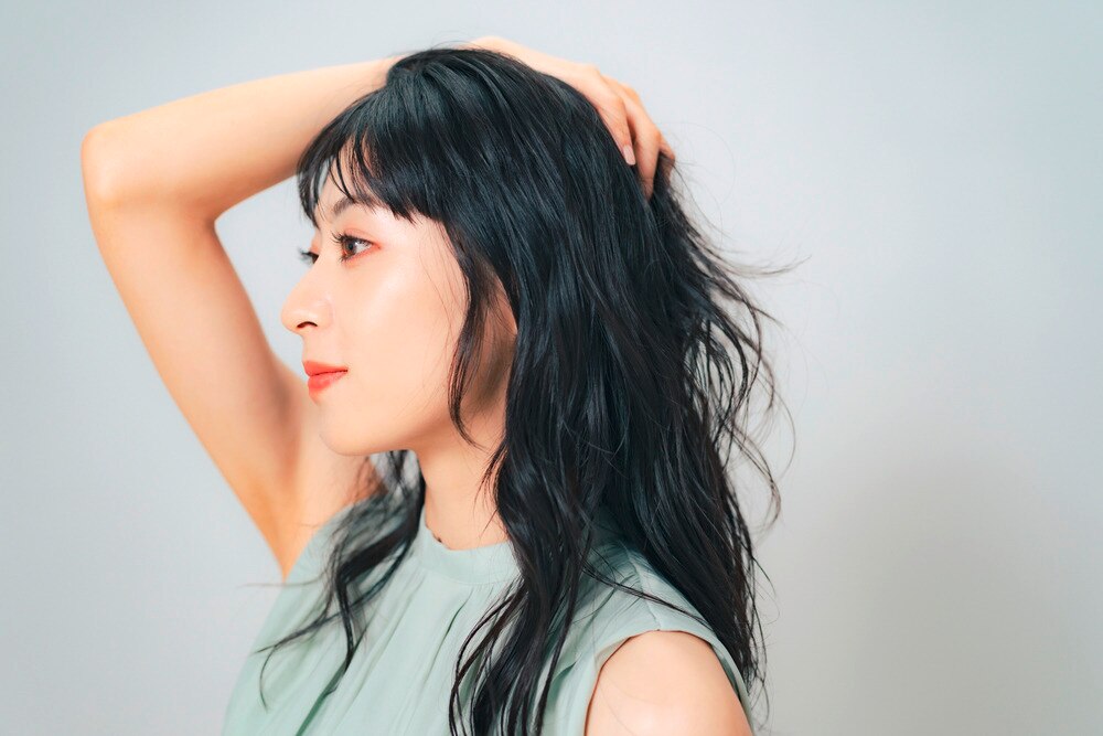 A side profile of woman with wavy black hair.