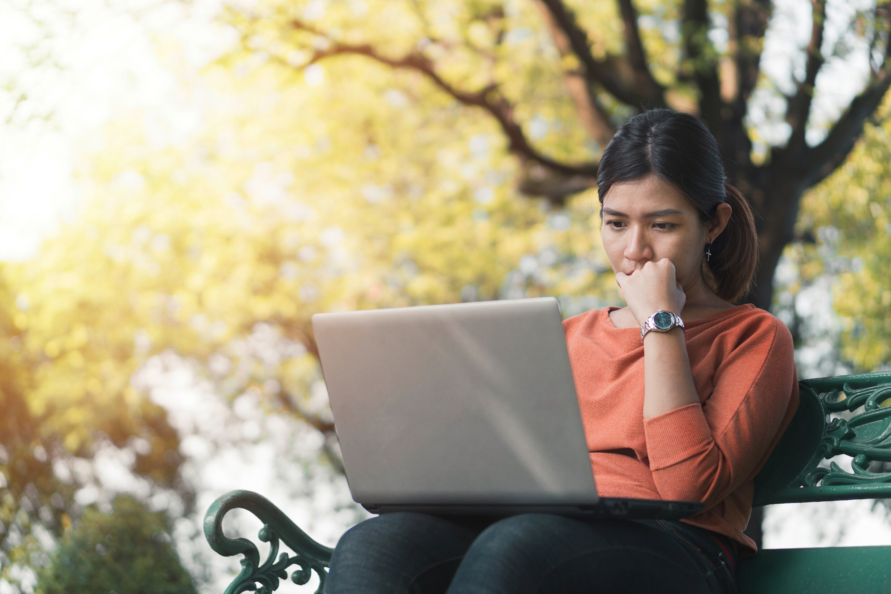 Asian woman in a pensive mood working outdoors