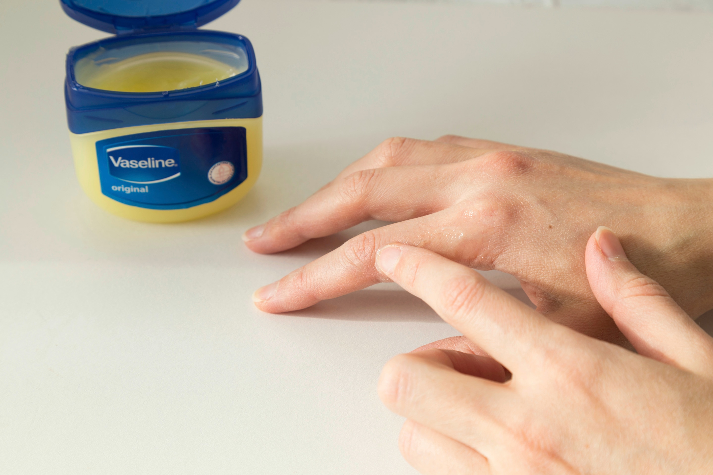 Woman applying Vaseline on hand