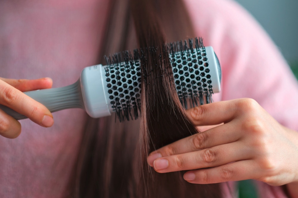 Closeup of a woman brushing her hair.