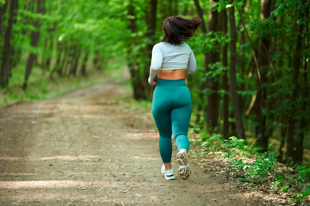 Woman with thick thighs running into the woods.