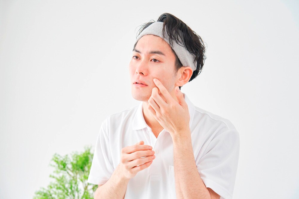 A portrait of man touching his cheek.