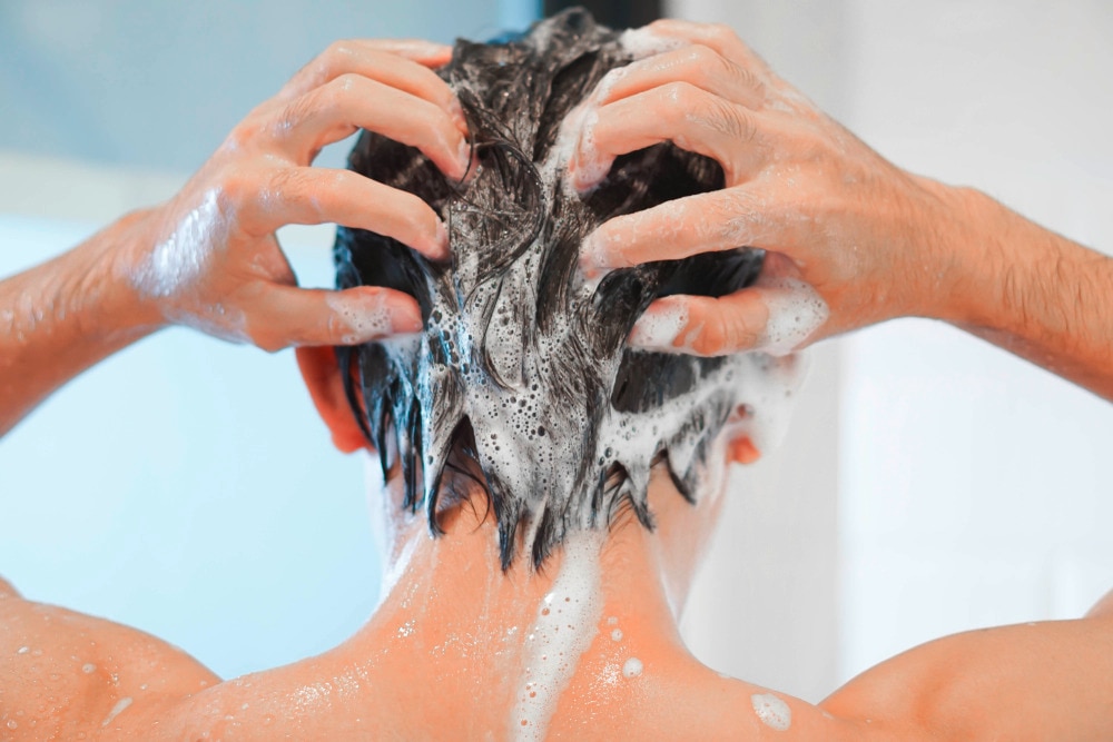 Backside of man shampooing his hair.