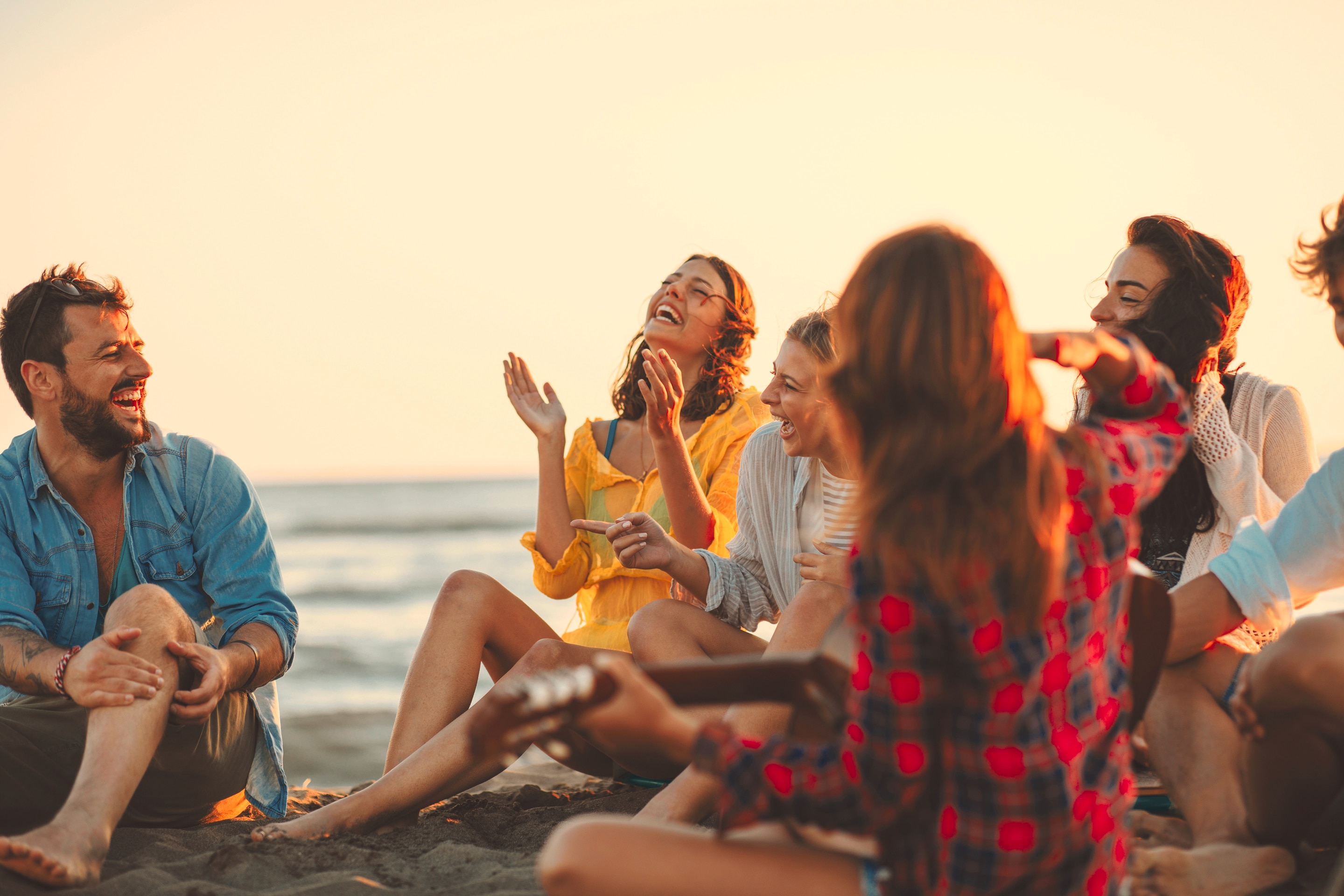A group of friends laughing at the beach.