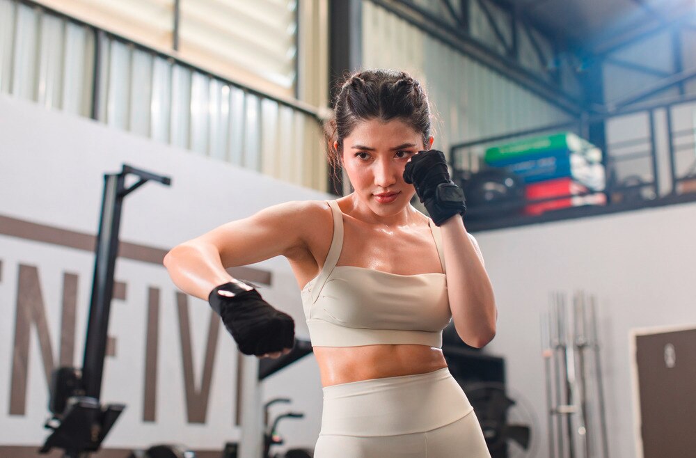 Muscular woman boxing with gloves.