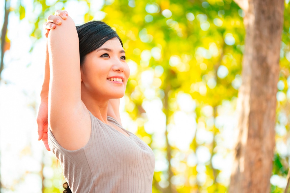 Woman raising her arms outdoors.