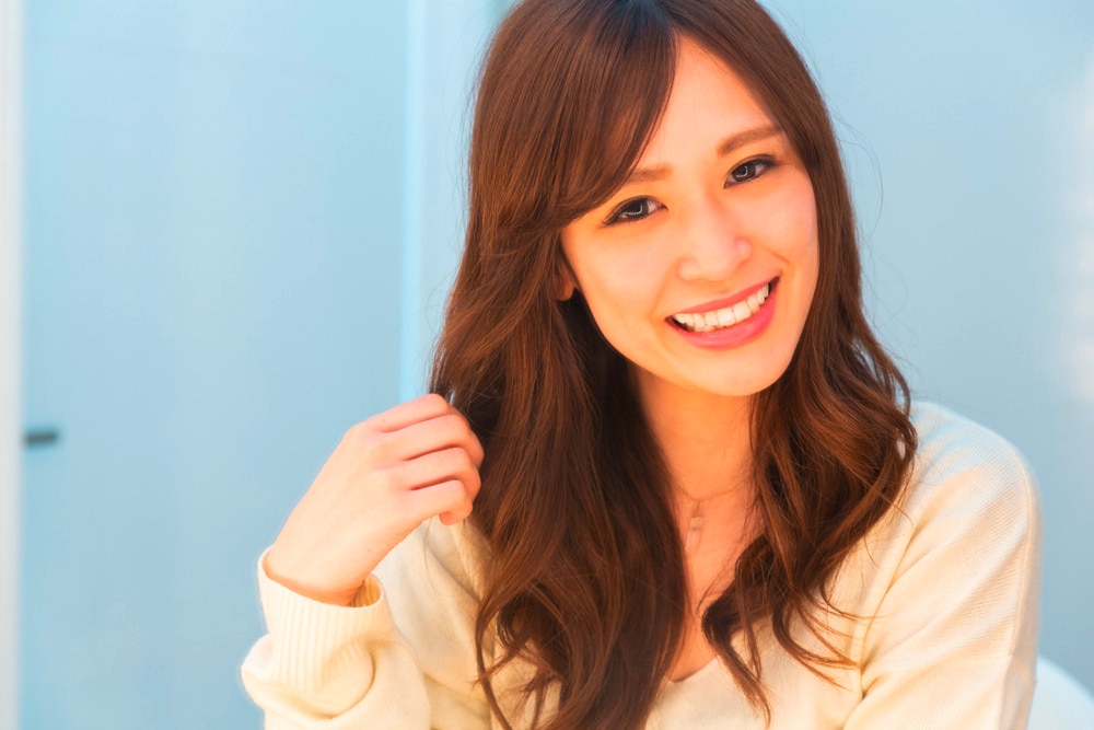Woman with light brown hair smiling to the camera.