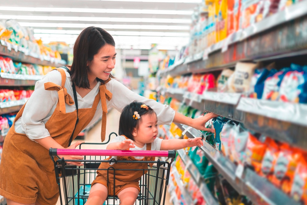 Mother shopping at a supermarket with her daughter.