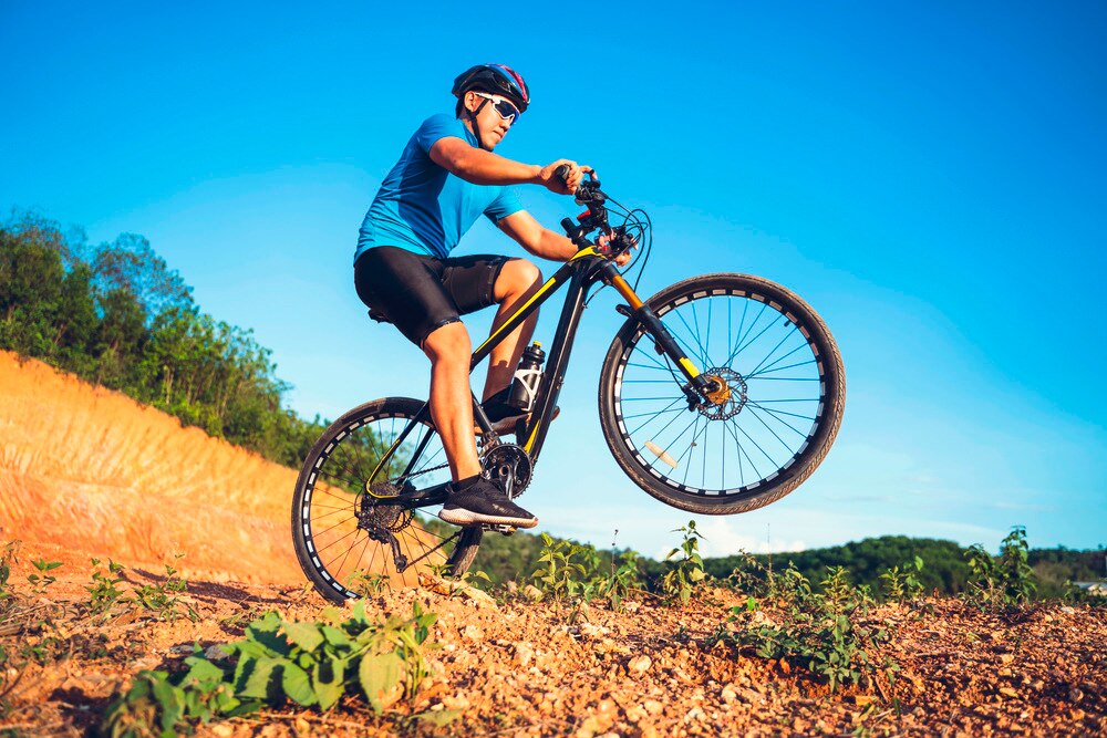 Man riding a mountain bike on rocky terrain trail.