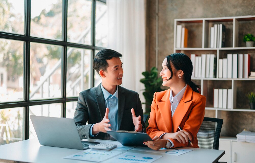 Man talking with a female colleague in a meeting room.