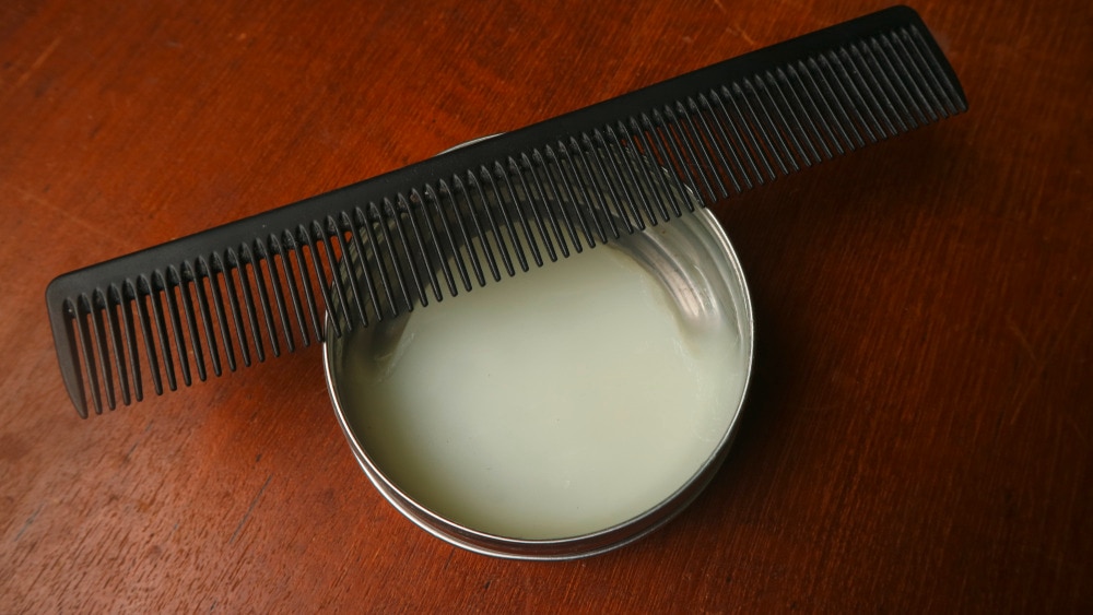 Closeup of hair pomade and a styling comb.