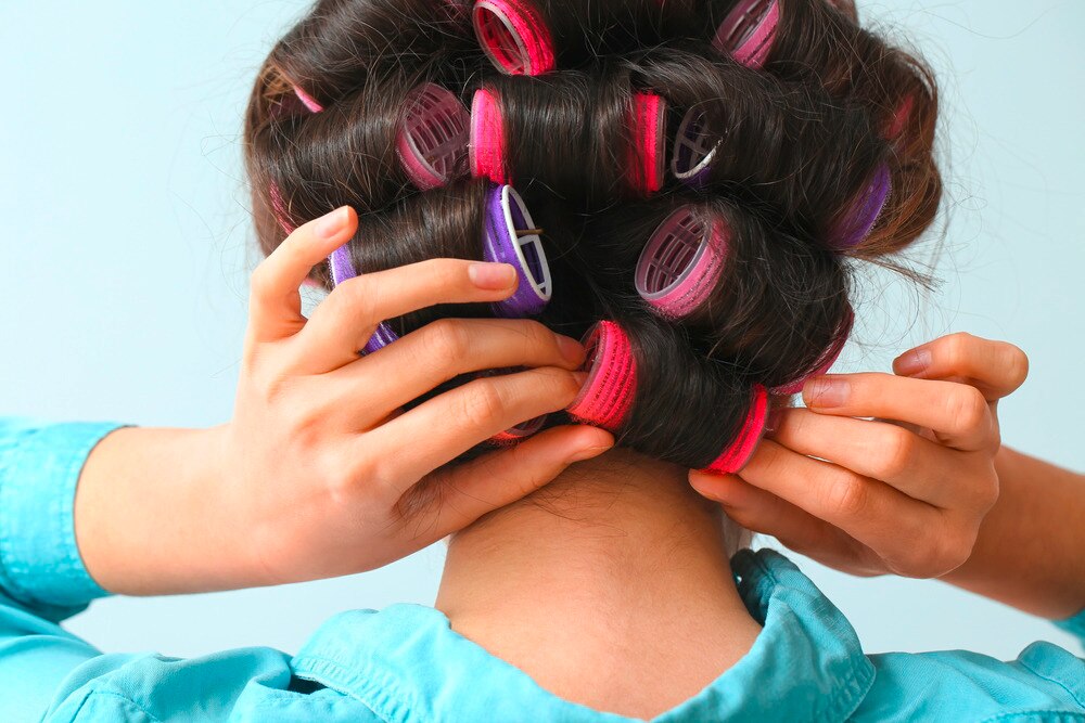 Woman with a lot of hair rollers on her head.