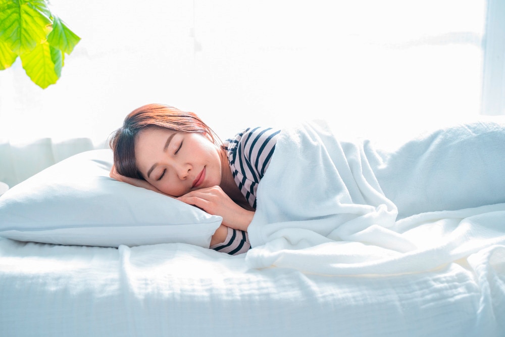 Portrait of a smiling woman sleeping on her bed
