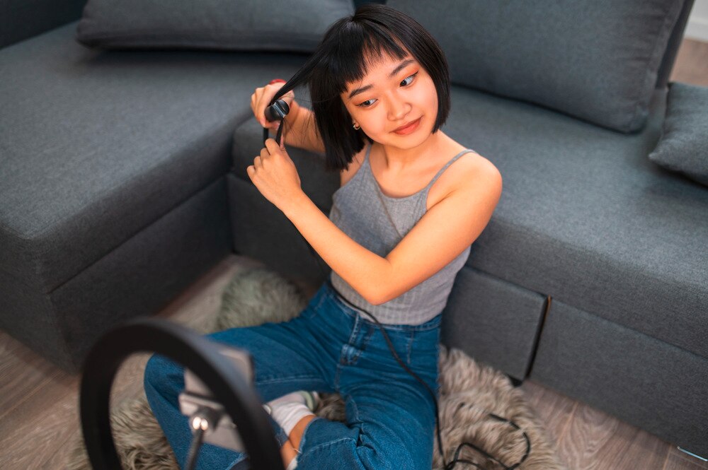 Woman curling her short hair with a curling iron.